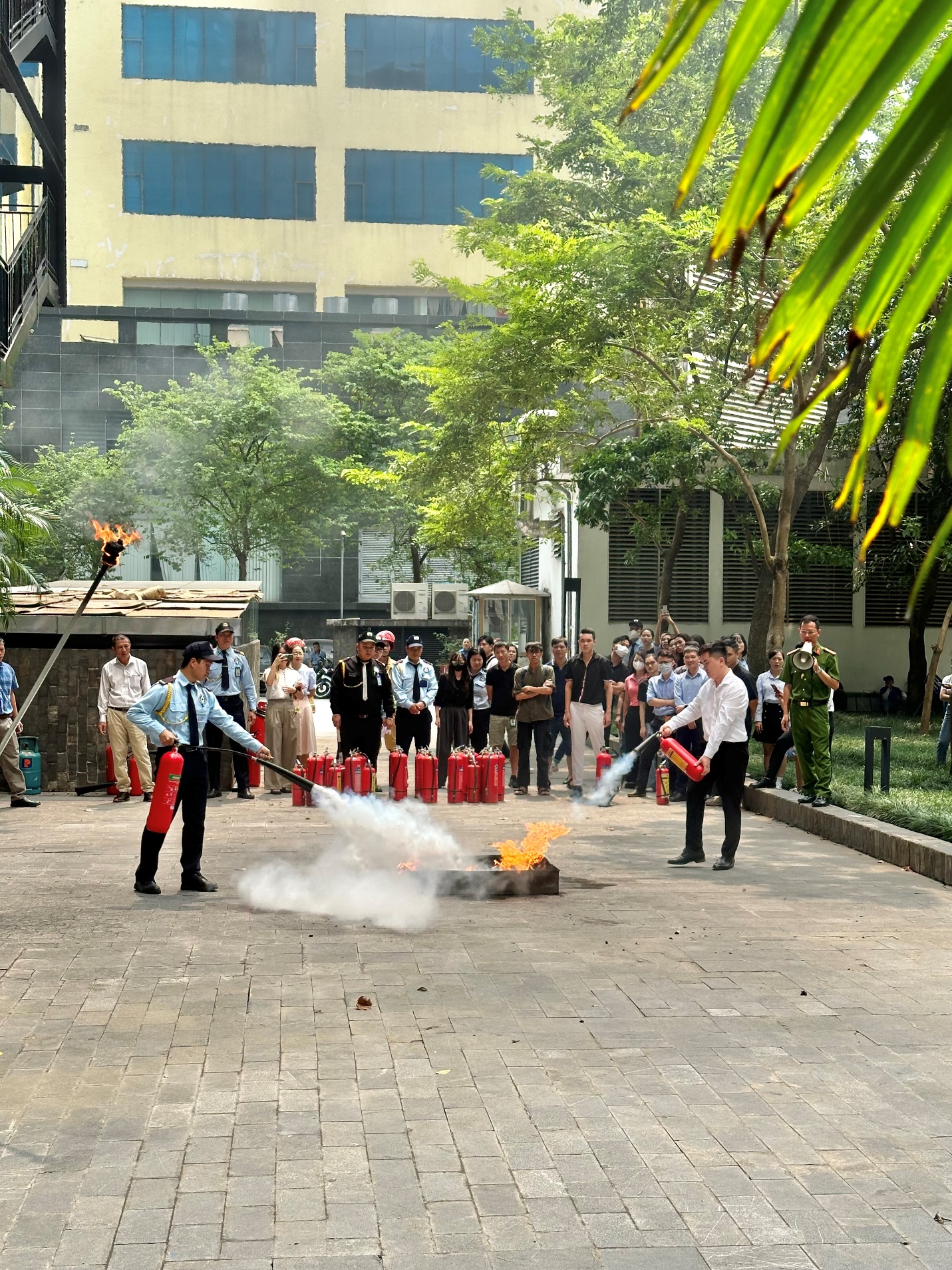 A group of people standing around a fire extinguisher

Description automatically generated