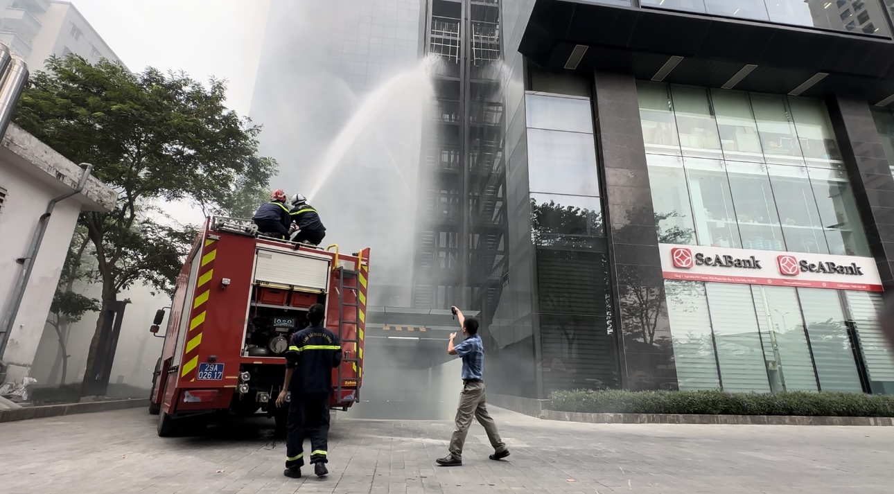 A firefighter spraying water on a fire truck

Description automatically generated